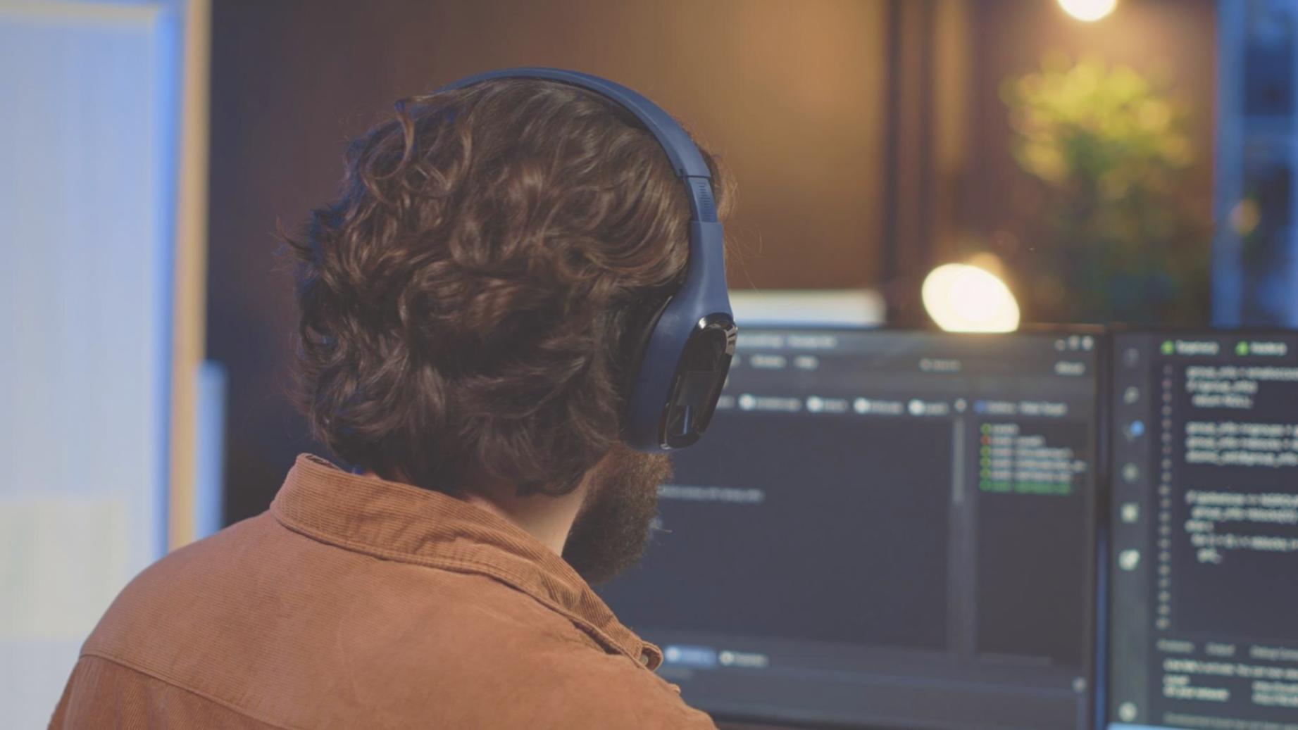 Student working on AI development project with multiple screens showing code and data visualizations